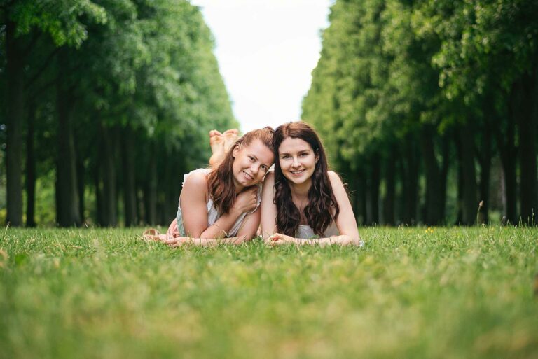© Thilo Gögelein Fotografie // Portraitfotografie zweier junger Frauen auf einer Wiese zwischen Bäumen